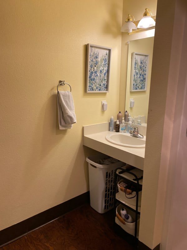 A neatly organized bathroom with a sink, mirror, and various toiletries.