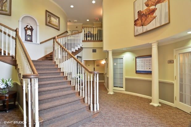 A spacious lobby with a central staircase and elegant decor.