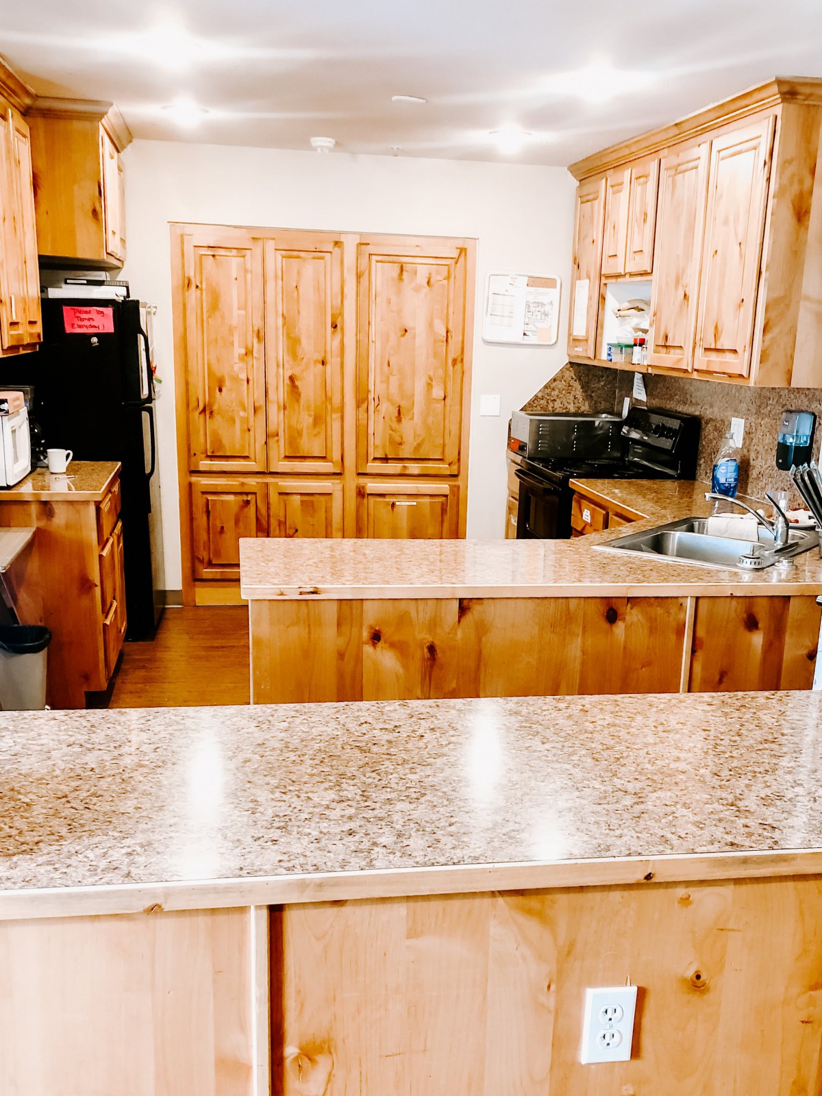 A kitchen with wooden cabinets and countertops featuring various appliances.