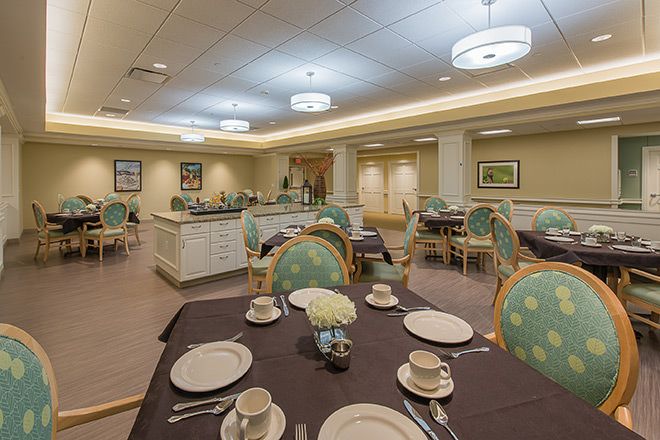 An elegantly set dining room with tables and chairs arranged for a meal.