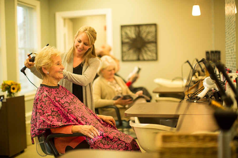 Elderly women enjoying a day at the hair salon, getting pampered by a friendly hairdresser.