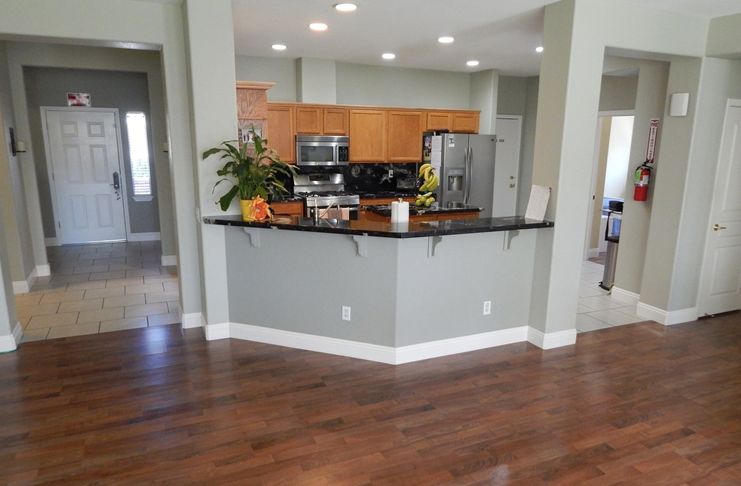 A modern kitchen with wood flooring and stainless steel appliances.