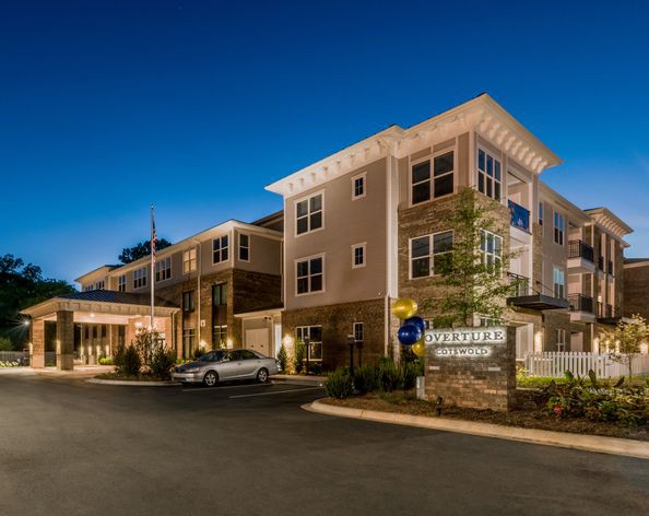 A modern hotel building illuminated at night.