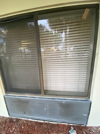 A window with closed blinds, showcasing the exterior of a building.
