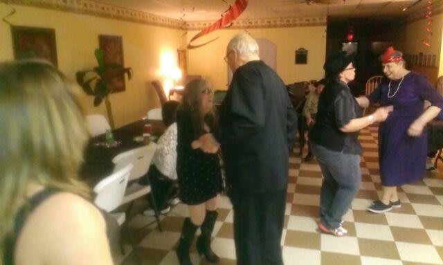 People dancing at a party in an indoor venue.