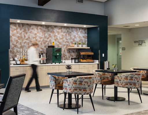 A modern caf interior featuring stylish furniture and a barista preparing beverages.