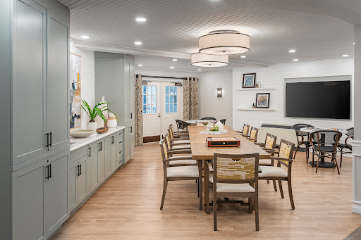A modern dining room featuring a spacious wooden table, stylish chairs, and contemporary lighting.