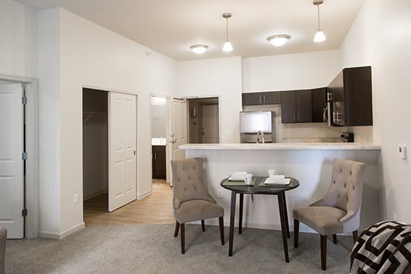 A modern apartment interior featuring a small dining area and a kitchen with minimalist design.