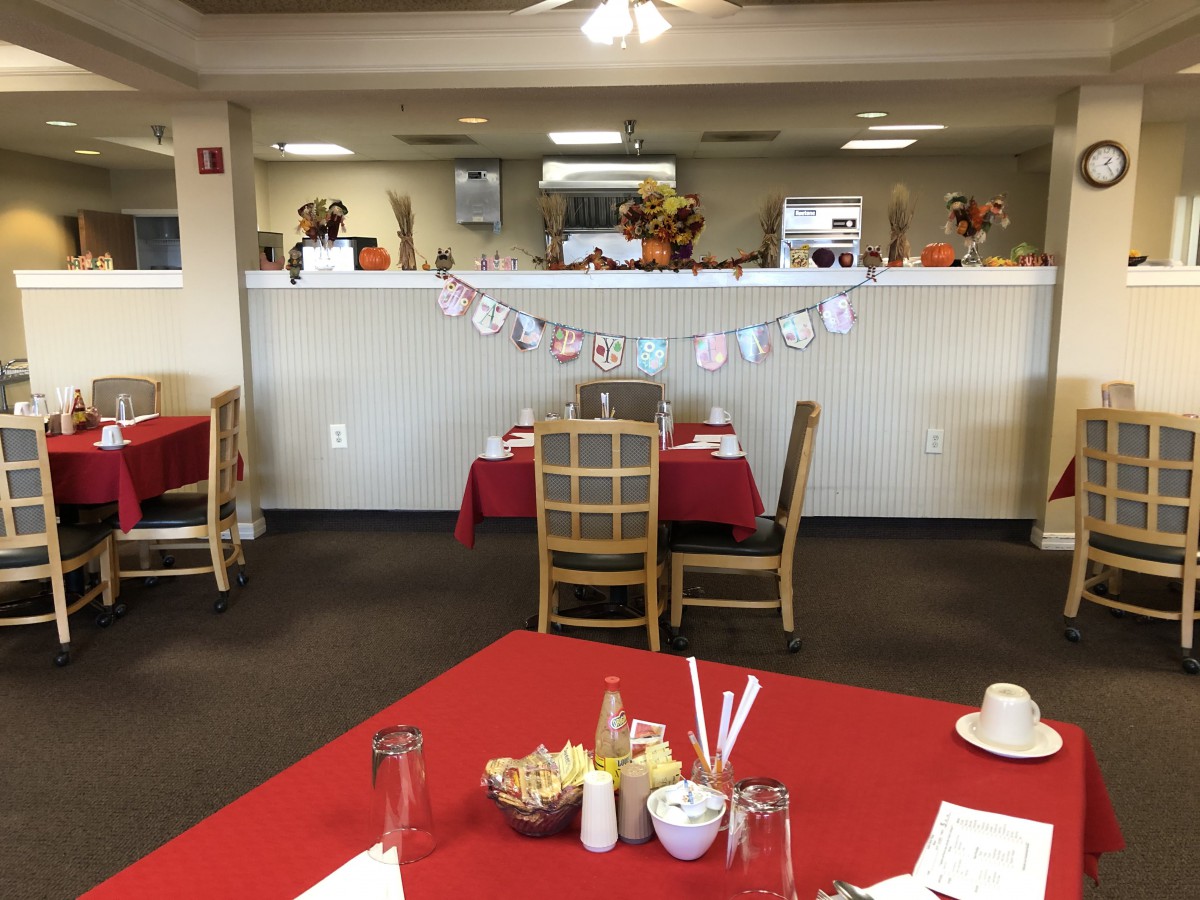 A cozy restaurant dining area with tables and chairs, featuring festive decorations.
