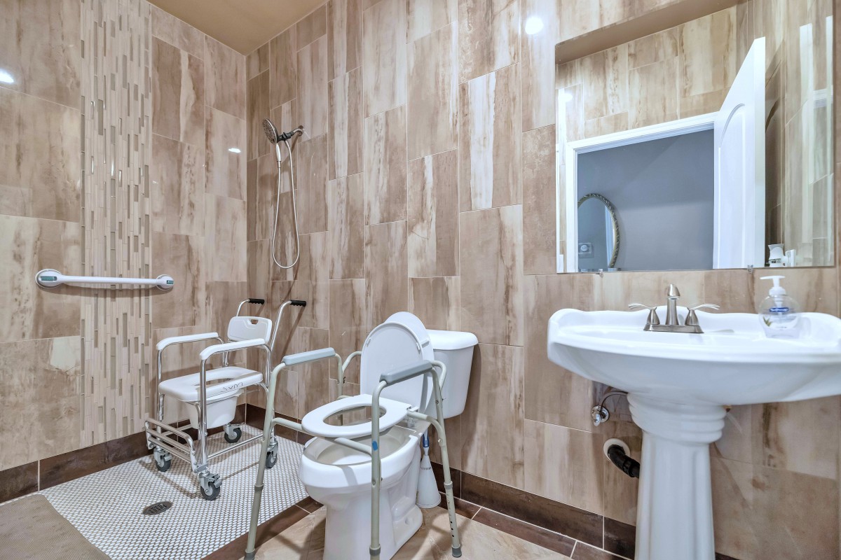 Accessible bathroom with handrails and shower area.