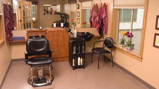 Interior of a cozy hair salon with chairs and hair-washing station.