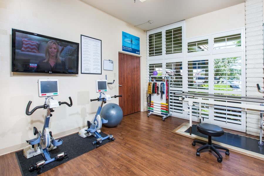 A well-equipped exercise room with stationary bikes and a television.