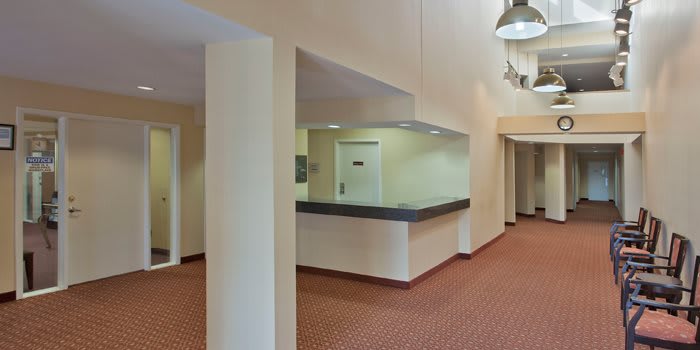 A quiet office lobby with a reception counter and hallway.