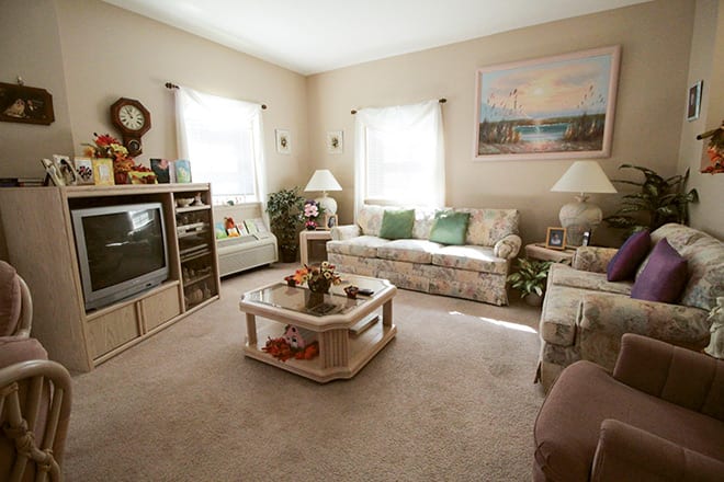 A cozy, vintage-themed living room with a television, sofa, and coffee table.