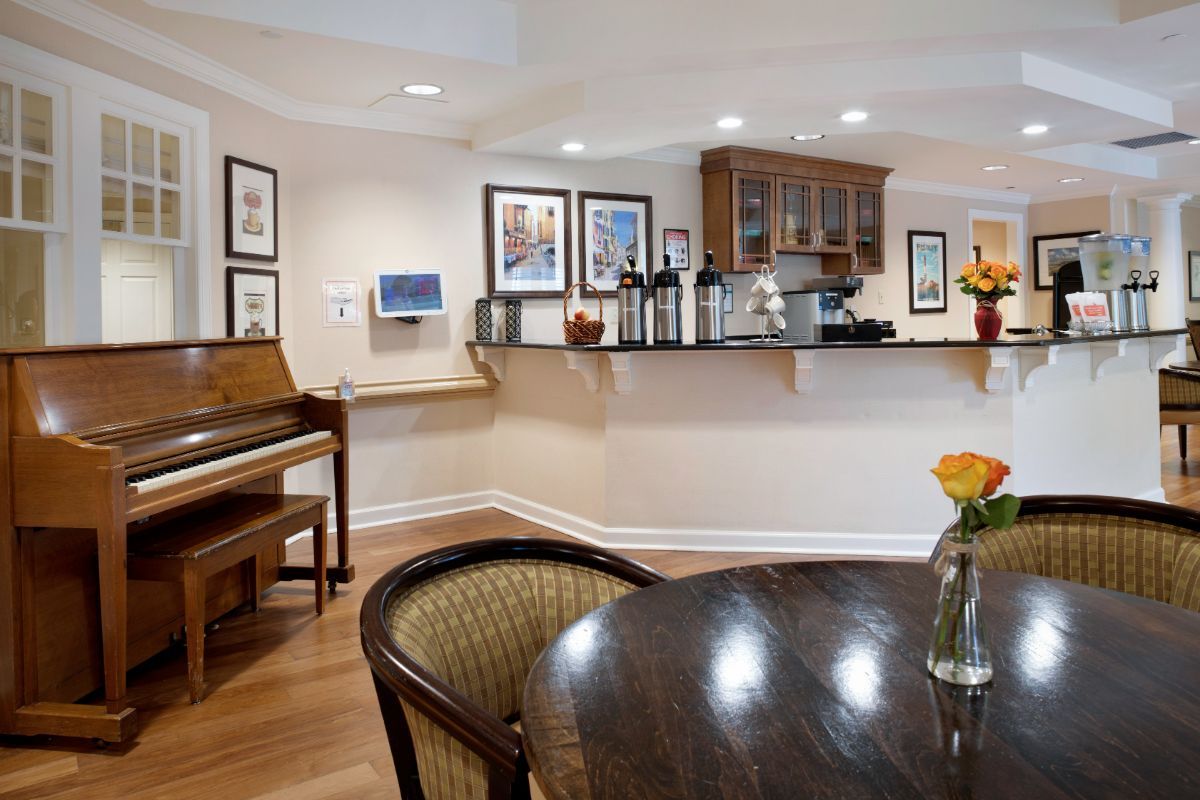 A cozy kitchen and dining area featuring a piano, wooden furniture, and stylish decor.
