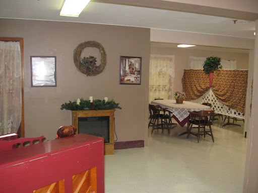 A cozy dining space featuring tables set for a gathering, complemented by warm decor and wall art.