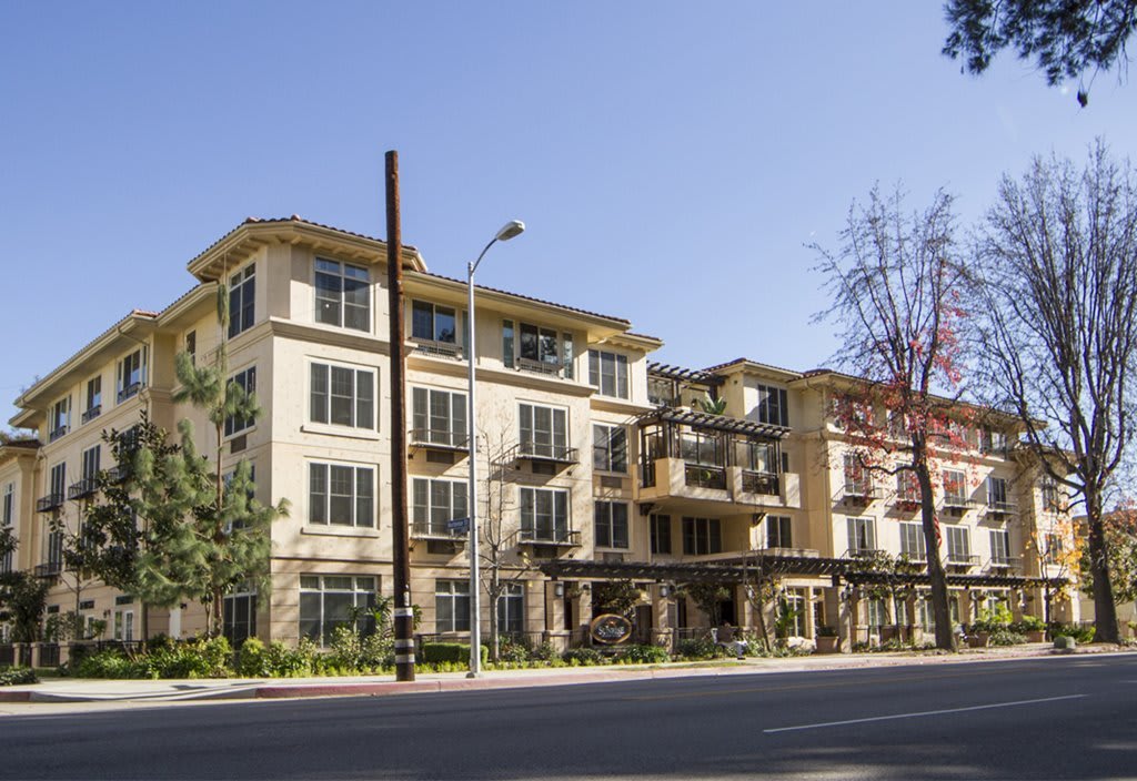 A modern multi-story apartment building along a city street.