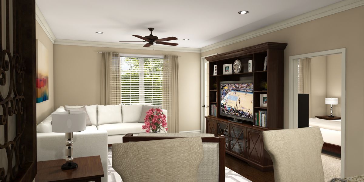 A cozy living room with a white sofa, a television set on a wooden entertainment unit, and natural light streaming through the window blinds.