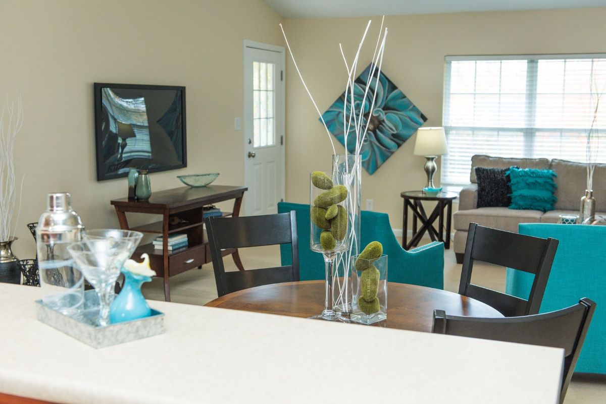 A modern living room with stylish home decor, featuring a table centerpiece and abstract wall art.