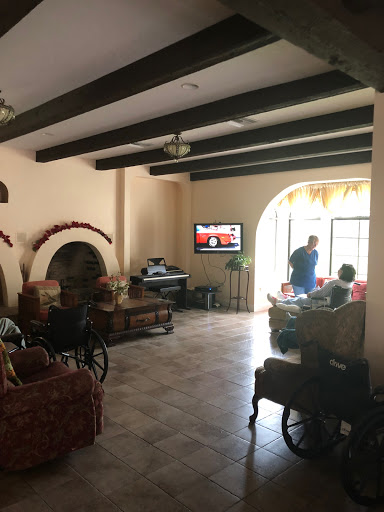 A cozy living room featuring comfortable seating and a television, illuminated by natural light.