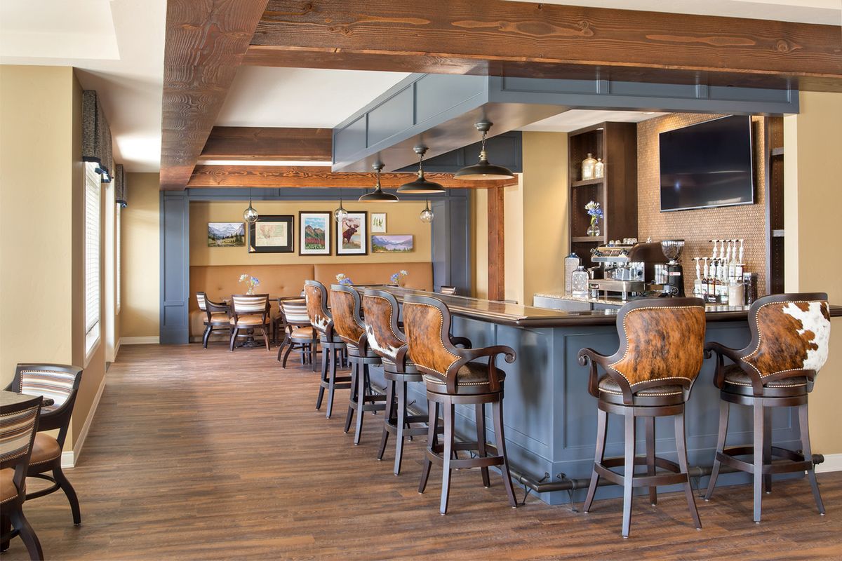 A modern bar interior with wooden flooring and stylish seating.