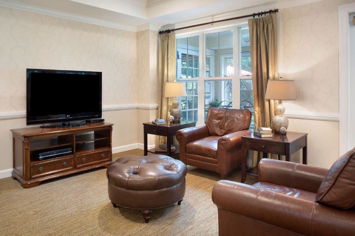 A cozy living room with leather furniture and a large window.