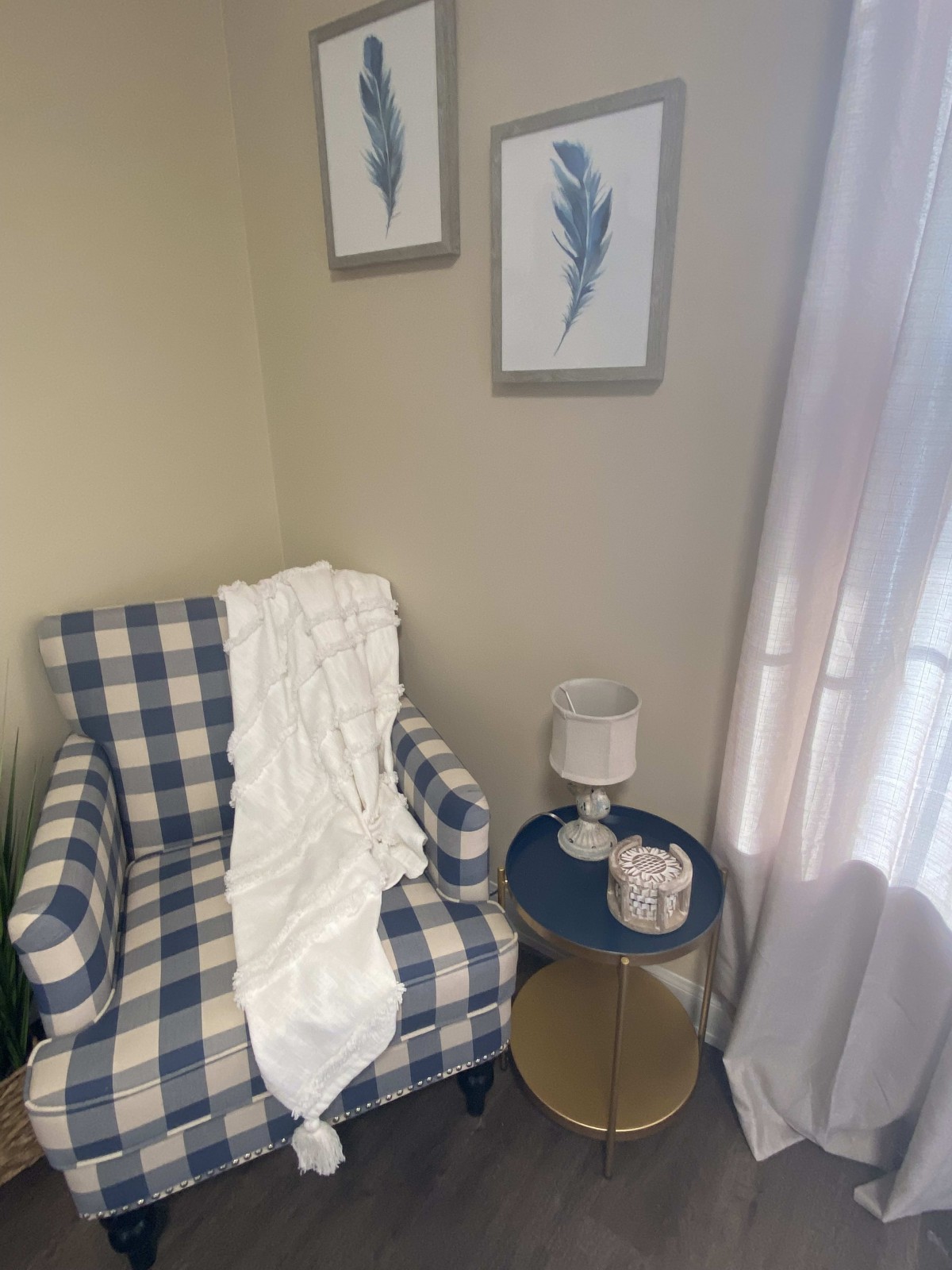 A cozy reading nook with a plaid armchair and a side table adorned with decor.