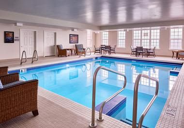An inviting indoor swimming pool with seating and a relaxation area.