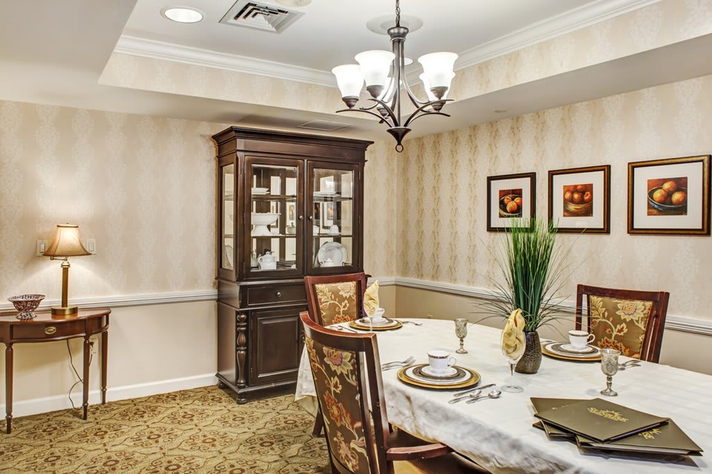 A cozy dining room with elegant furnishings and a beautifully set table.