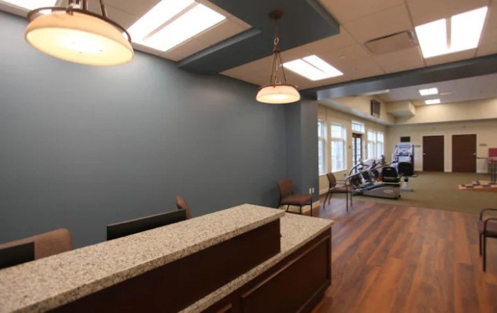 A modern office reception area with a desk and seating.
