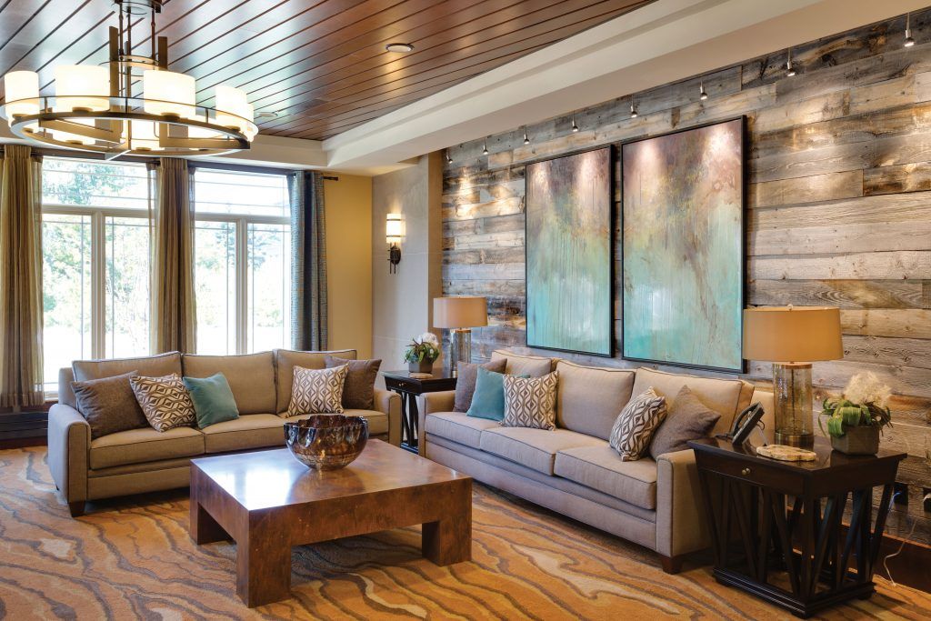 A cozy living room with comfortable sofas, a wooden coffee table, and large artworks on the wall.