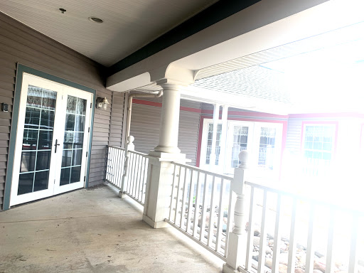 A bright and inviting porch area featuring elegant columns and a view of the outdoors.