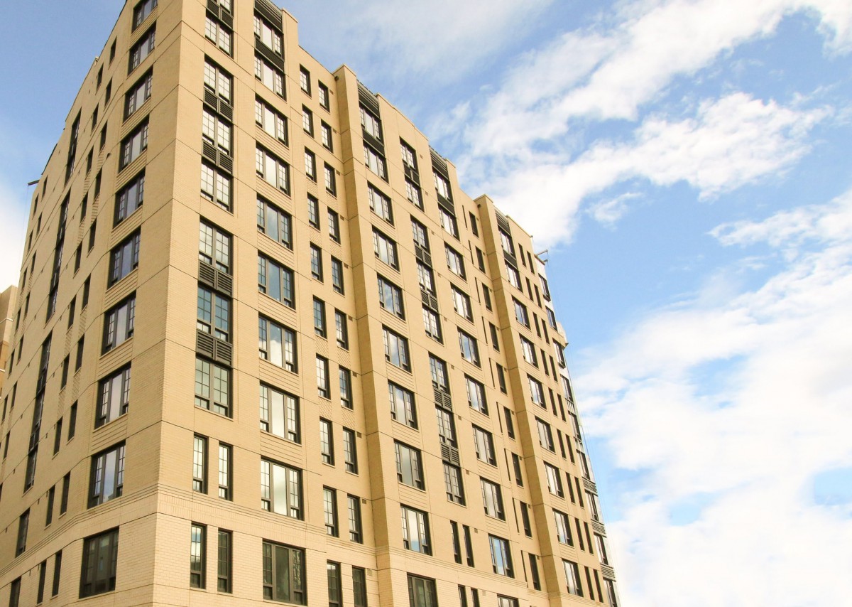 A modern apartment building under a partly cloudy sky.