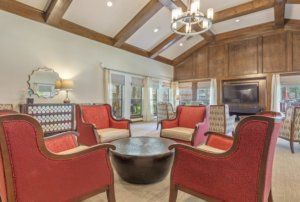 Cozy living room with red armchairs and wooden beam ceiling.