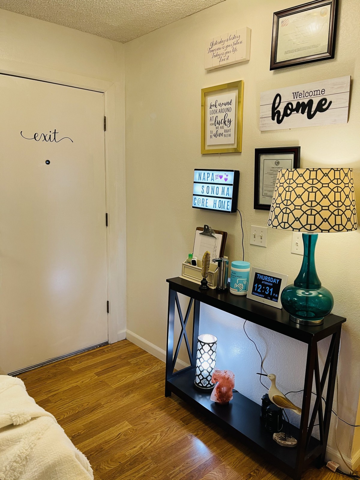 A cozy entryway with decorative wall art, a table lamp, and welcoming home decor.
