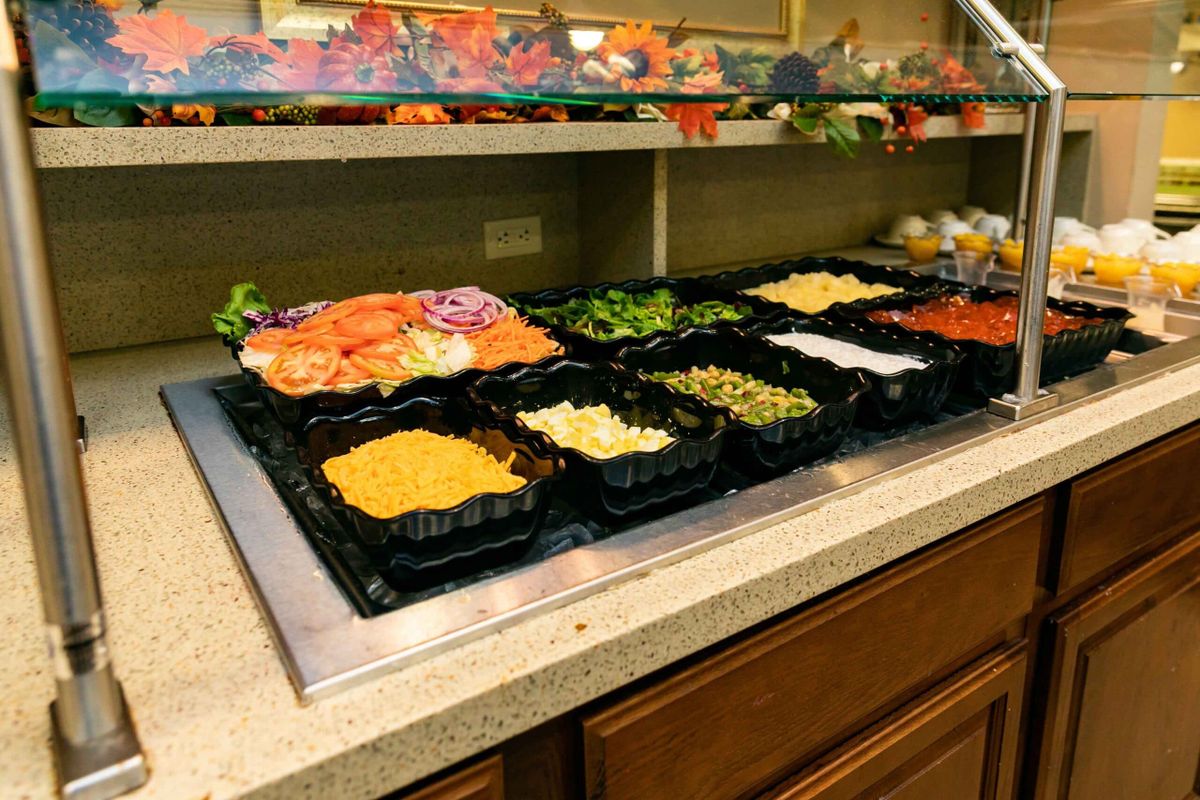 A well-stocked salad bar featuring a variety of fresh vegetables and toppings.