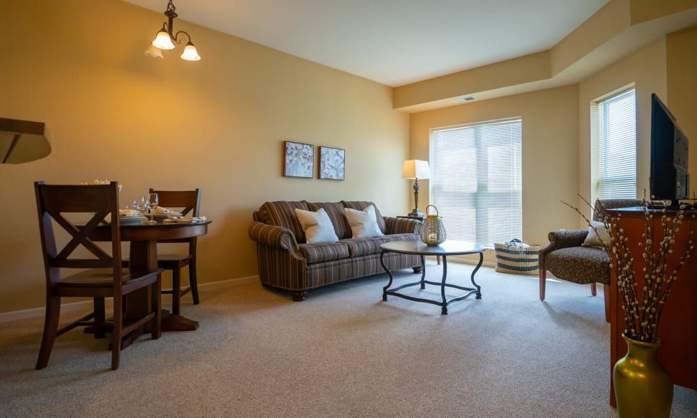 A cozy living room with a sofa, coffee table, and a window bringing in natural light.