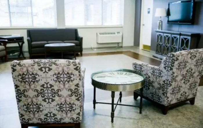 A modern office lobby featuring patterned chairs and a round table.