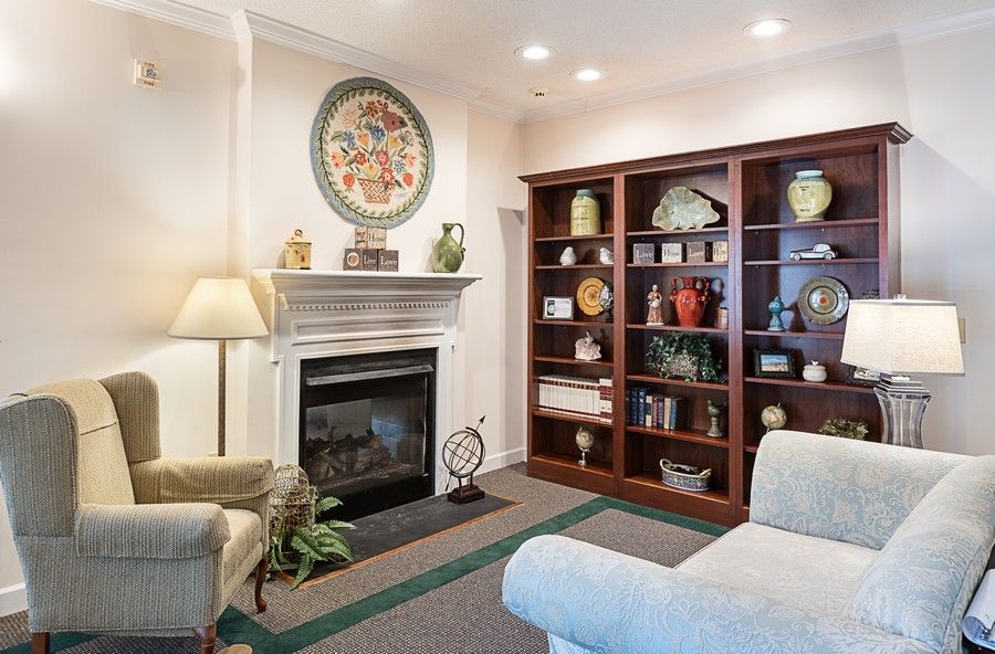 A cozy living room featuring a fireplace, wooden bookshelf, and comfortable seating.