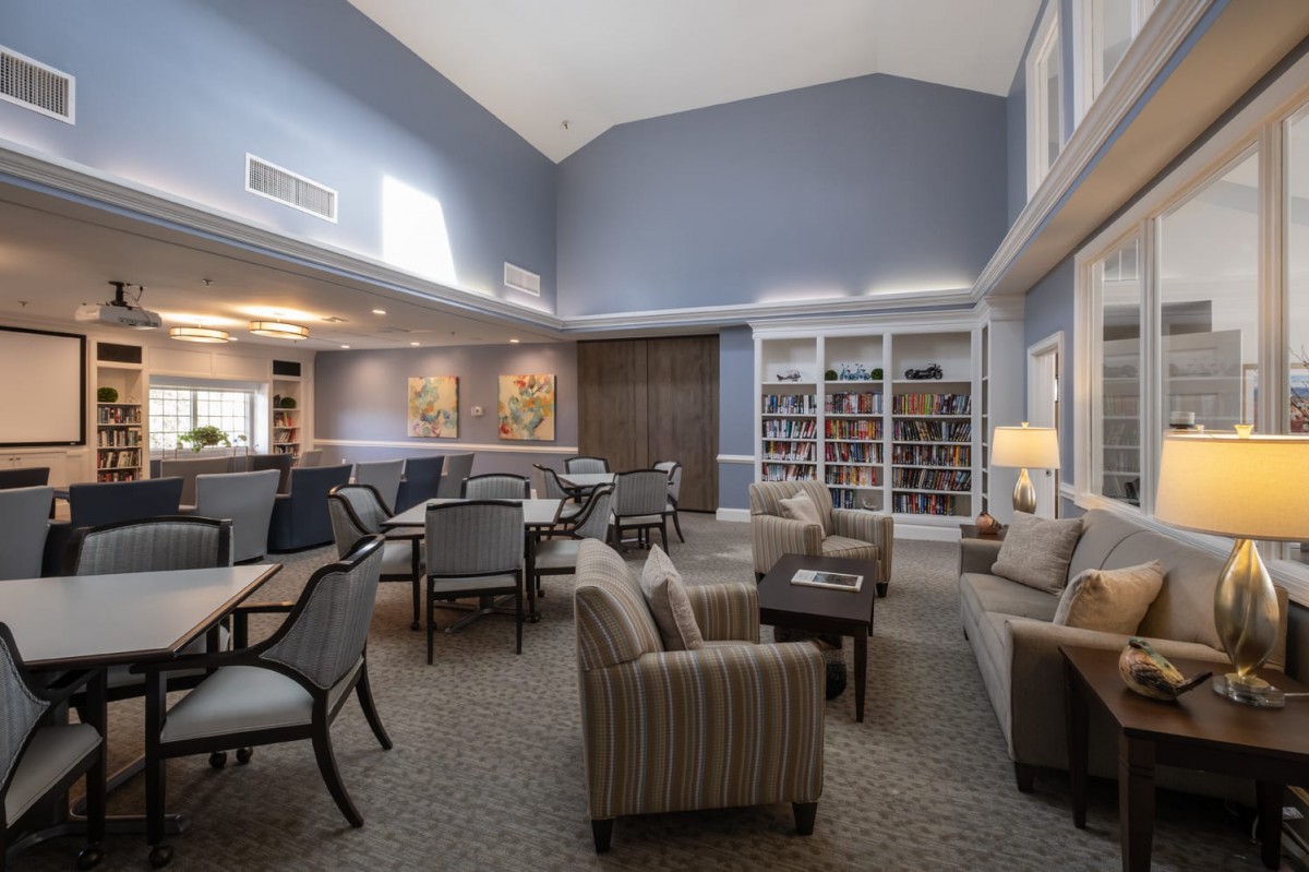 A spacious living room with comfortable seating and a library section.