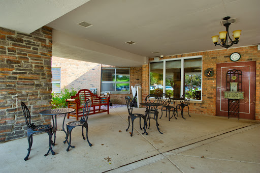 A cozy outdoor caf area featuring wrought iron tables and chairs, perfect for enjoying a meal or drink surrounded by greenery.