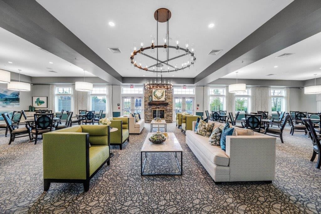 A modern and spacious living room with elegant furniture and a central chandelier.