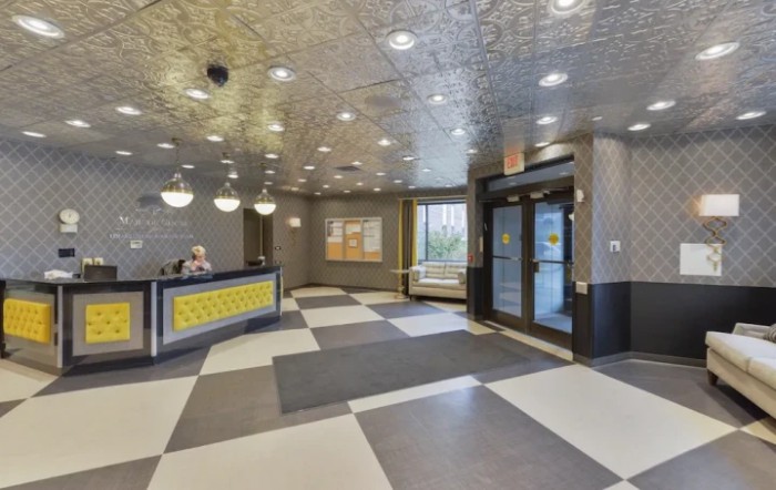 Modern lobby area with a reception desk and entrance doors.