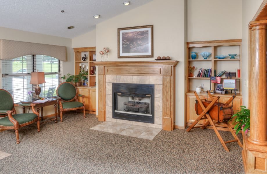 A cozy living room with a fireplace, bookshelf, and comfortable seating.