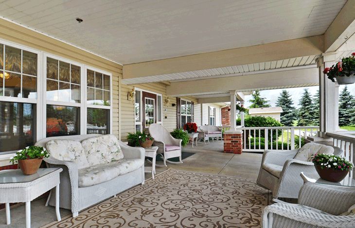 A cozy outdoor porch with comfortable seating and decorative elements.