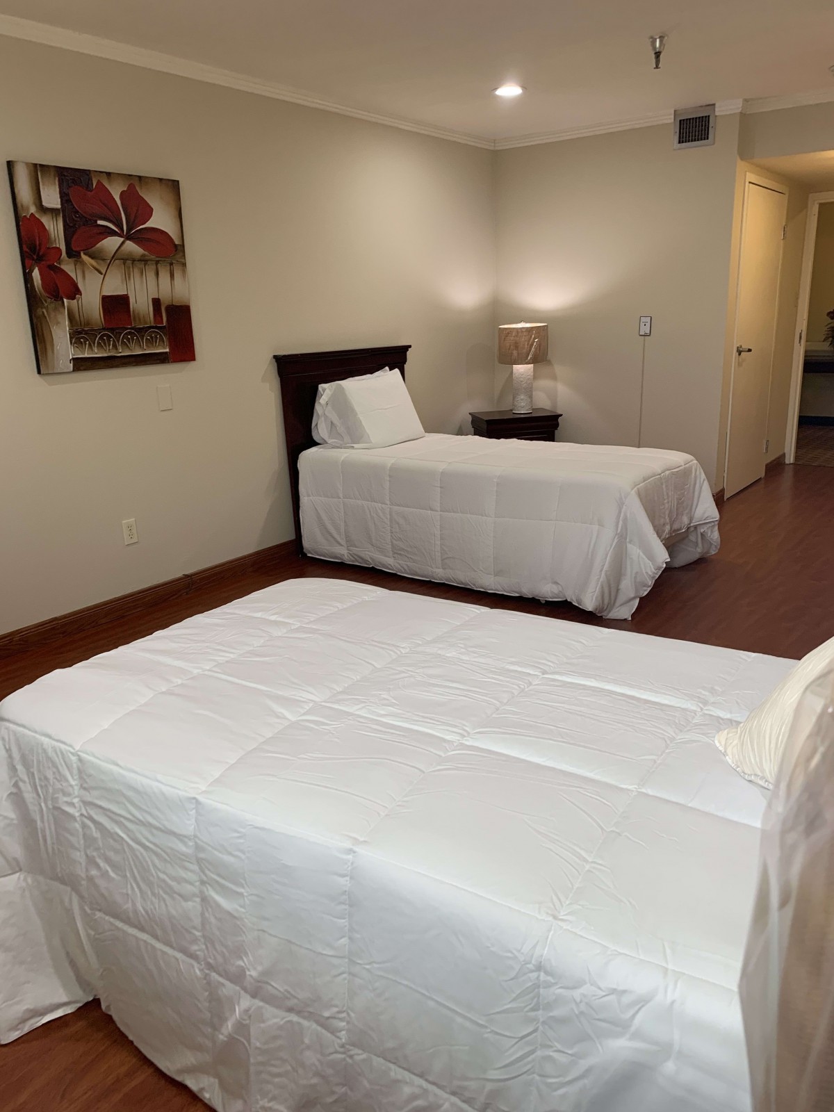 A neatly arranged bedroom with two single beds and a nightstand between them.