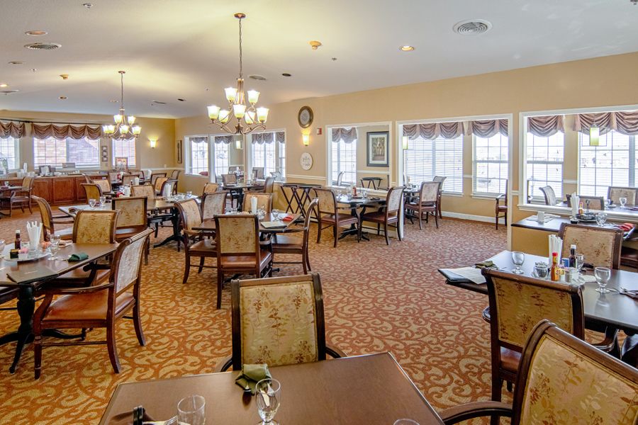 A spacious and well-lit dining area with neatly arranged tables and chairs.