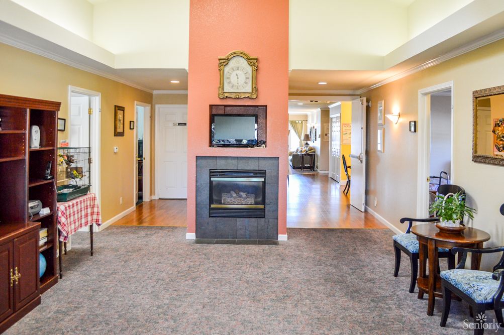 A cozy living room with a central fireplace and decorative clock.