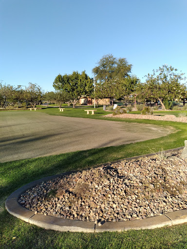 A scenic view of a golf course, showcasing well-maintained greens and surrounding trees.