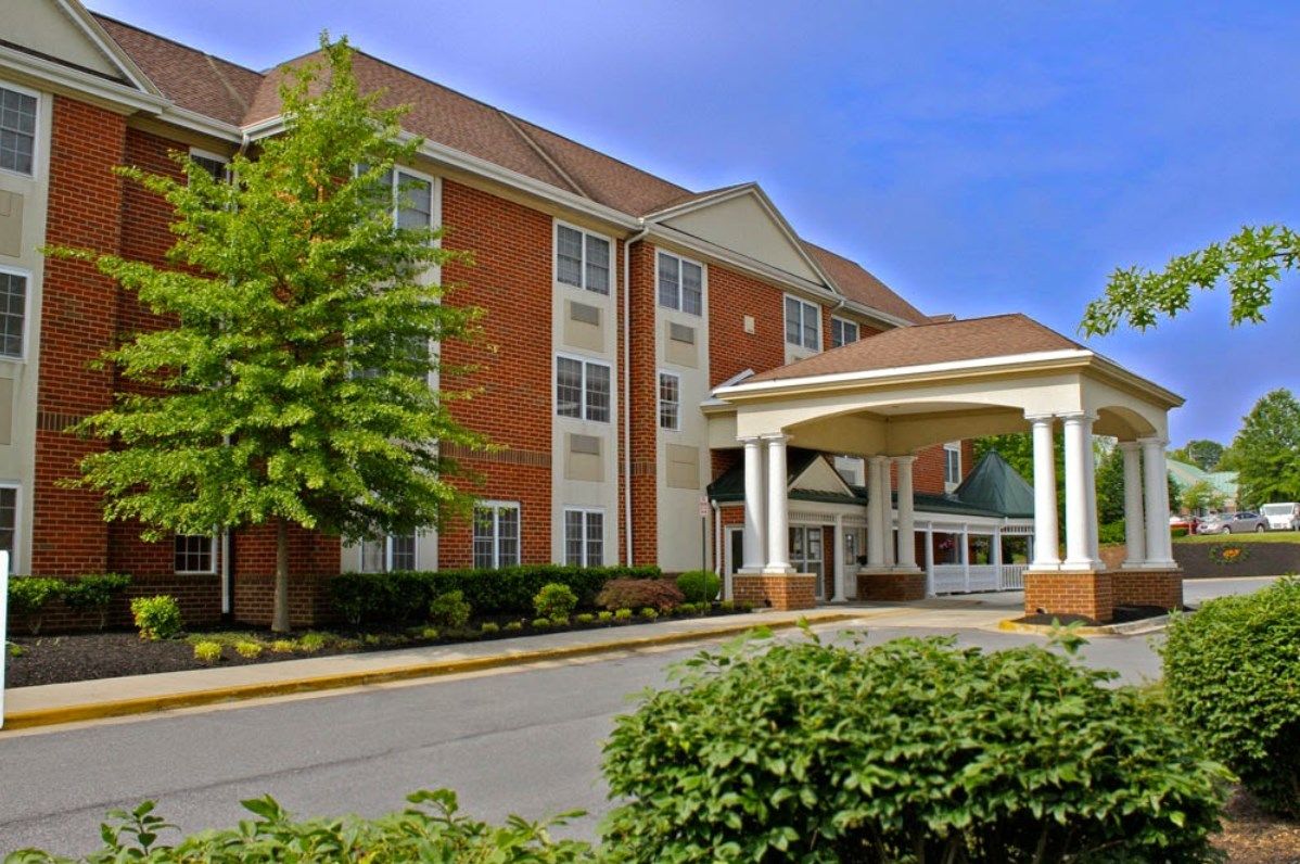A hotel building with a covered entrance and landscaped surroundings.